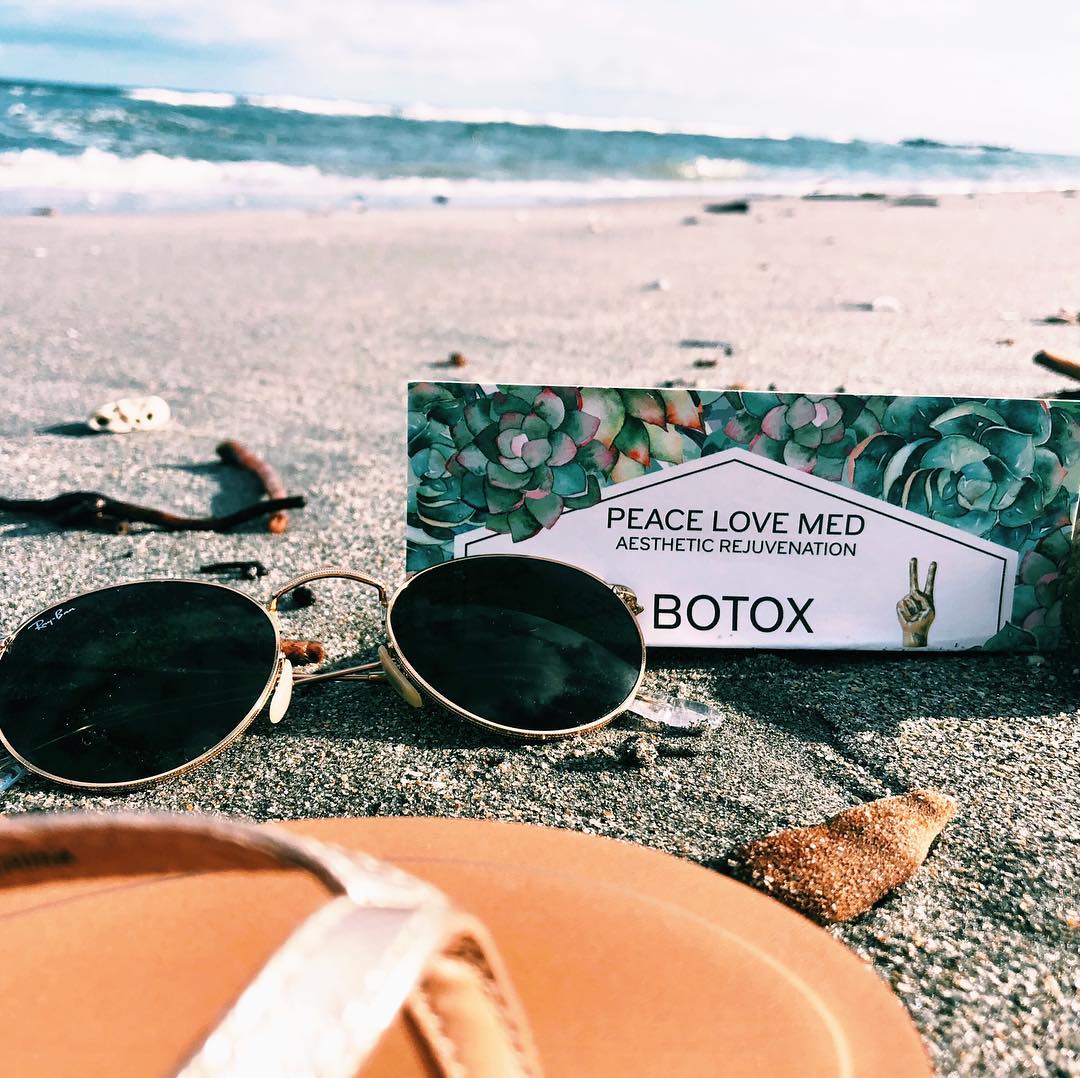 Sunglasses, sandals and a flyer on a beach Sunglasses, sandals and a Peace.Love.Med. flyer on a beach