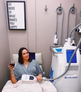 Woman celebrating successful cosmetic procedure drinking wine