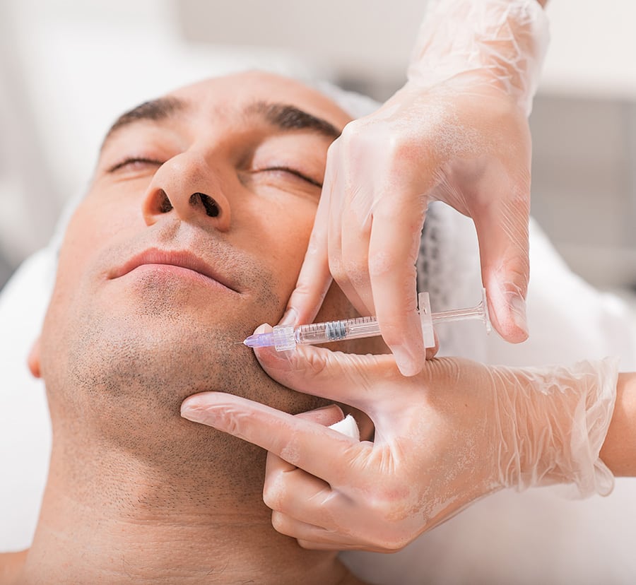 A man receiving an injection on his chin A man receiving an injection on his chin at Peace.Love.Med.